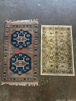 Two small rugs side by side on floor showing full designs