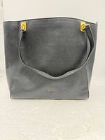 Front view of black leather tote showing gold hardware and RLL logo