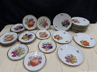 Front view showing assorted 9" and 7.5" plates with fruit designs and gold rims