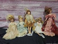 Group of five Victorian-style porcelain dolls displayed together