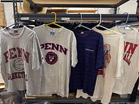 Five Penn graphic shirts on hangers