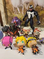 Group shot showing all figures including Venom, mecha, top-hat figure and seven Funko Pops