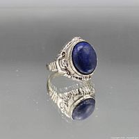Front view of ring on mirror showing stone, bezel and overall design