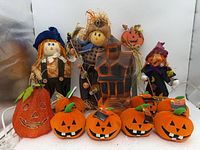 Group shot showing all items: blow-mold house, plush pumpkins, glitter pumpkin, scarecrows, witch