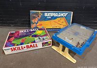 Group shot of the three games: Skill-Ball box, Bumper Shot box, hockey tabletop unit