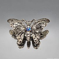 Front view of silvertone butterfly brooch with clear and blue rhinestones