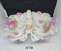 Top view of porcelain divided serving dish showing floral decoration and lobster handle