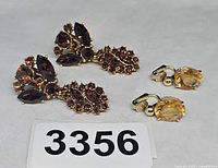 Both pairs of clip-on earrings displayed together showing design and color