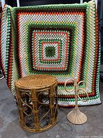 All three items together: rattan stool, wicker stand, crochet afghan backdrop