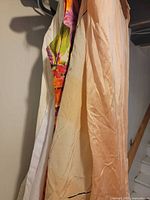 Multiple garments hanging, showing floral dress and peach slip