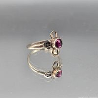 Side view of sterling ring showing purple cabochon and decorative shoulders