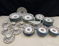 Full set laid out showing stacks of plates, bowls, cups, saucers, gravy boat