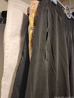 white pants, paisley pants, black pants side view on hanger