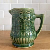 Front view of green glazed stoneware pitcher