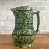 Front view of green embossed stoneware pitcher