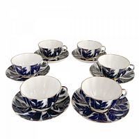 Six matching cobalt blue and gold porcelain cup and saucer sets on white background