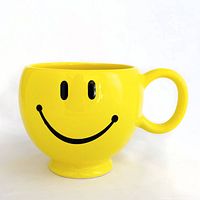 front view of yellow smiley face mug