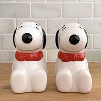Front view of both Snoopy shakers showing faces and collars