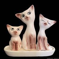 Front view of ceramic cat family set assembled on base