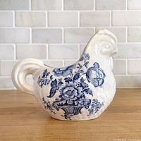 Side profile of chicken-shaped creamer showing blue floral transfer pattern