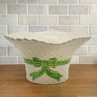 Front view showing straw texture, scalloped rim, green bow