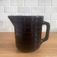 Front view showing ribbed body, spout and handle