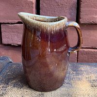 Front view of glossy brown drip glaze pitcher