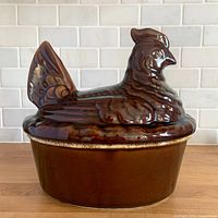Side profile showing hen-shaped lid seated on round base