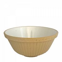 Side view of yellow ware Mason Cash stoneware mixing bowl showing ribbed exterior and scalloped rim