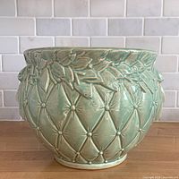 Front view of aqua glazed McCoy Tierra Cushion jardiniere showing diamond quilting and leaf rim