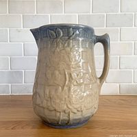 Front of beige and blue fade ceramic pitcher