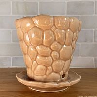 Front view of peach pebble-textured planter showing overall shape and glaze