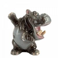 Front angled view of ceramic hippopotamus shaker showing open mouth, tusks, raised arm, glazing and overall form