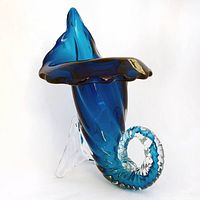 Front angled view showing blue cased glass body, clear glass tail and base
