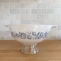 Side view showing blue floral pattern on white milk glass bowl