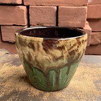 Side view showing brown and green drip glaze and planter shape