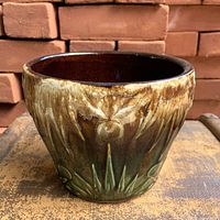 Front view of planter showing drip glaze and embossed celestial design