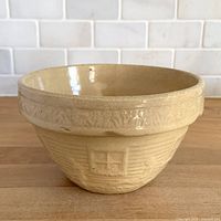 Angled top view of glazed yellow ware mixing bowl
