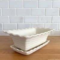 planter on underplate angled view showing wave relief and scalloped rim