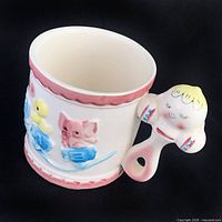 Front view showing embossed train, chick, elephant and rattle handle
