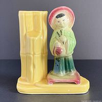 Front view showing yellow bamboo vessel and Asian figure