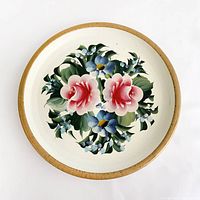 Top view of round tray showing floral artwork and gold rim