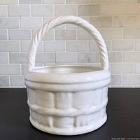 Front view of glossy white ceramic basket planter with rope style handle