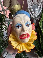 Front view of painted plaster clown wall plaque showing facial details and yellow collar