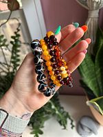 All four glass bead stretch bracelets held in hand showing colours and bead styles
