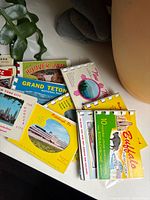 Top view showing multiple souvenir booklets including Hoover Dam, Grand Teton, Buffalo, New Orleans, New York City