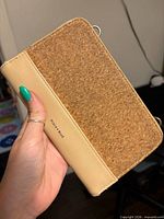 Front view showing cork panel, Pixie Mood logo, beige faux leather section and D-rings