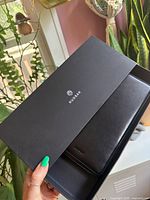 Branded Rudsak box opened showing black leather wallet inside