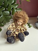 Front view showing faux-fur mane, leopard-print body, felt paws