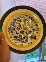 Front view of Staffordshire decorative plate held in hand